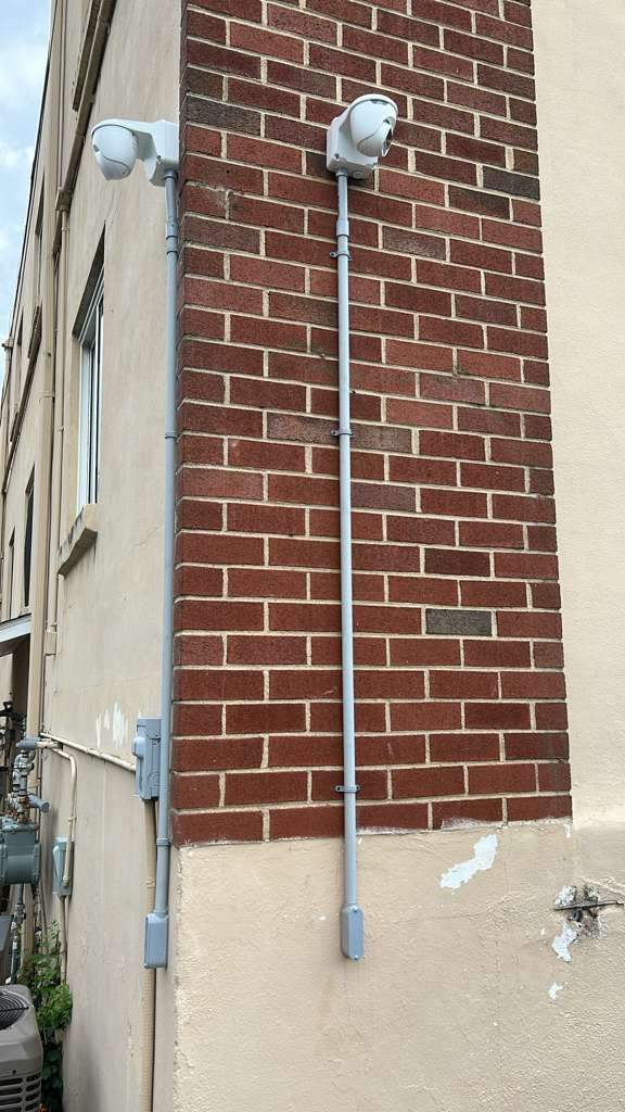 Two security cameras mounted on a brick building corner