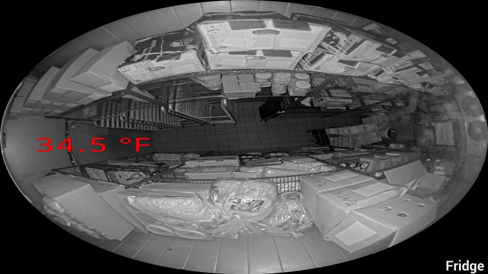 Infrared fridge camera view with a live 34.5°F temperature reading stamped on the footage, shot with the door closed