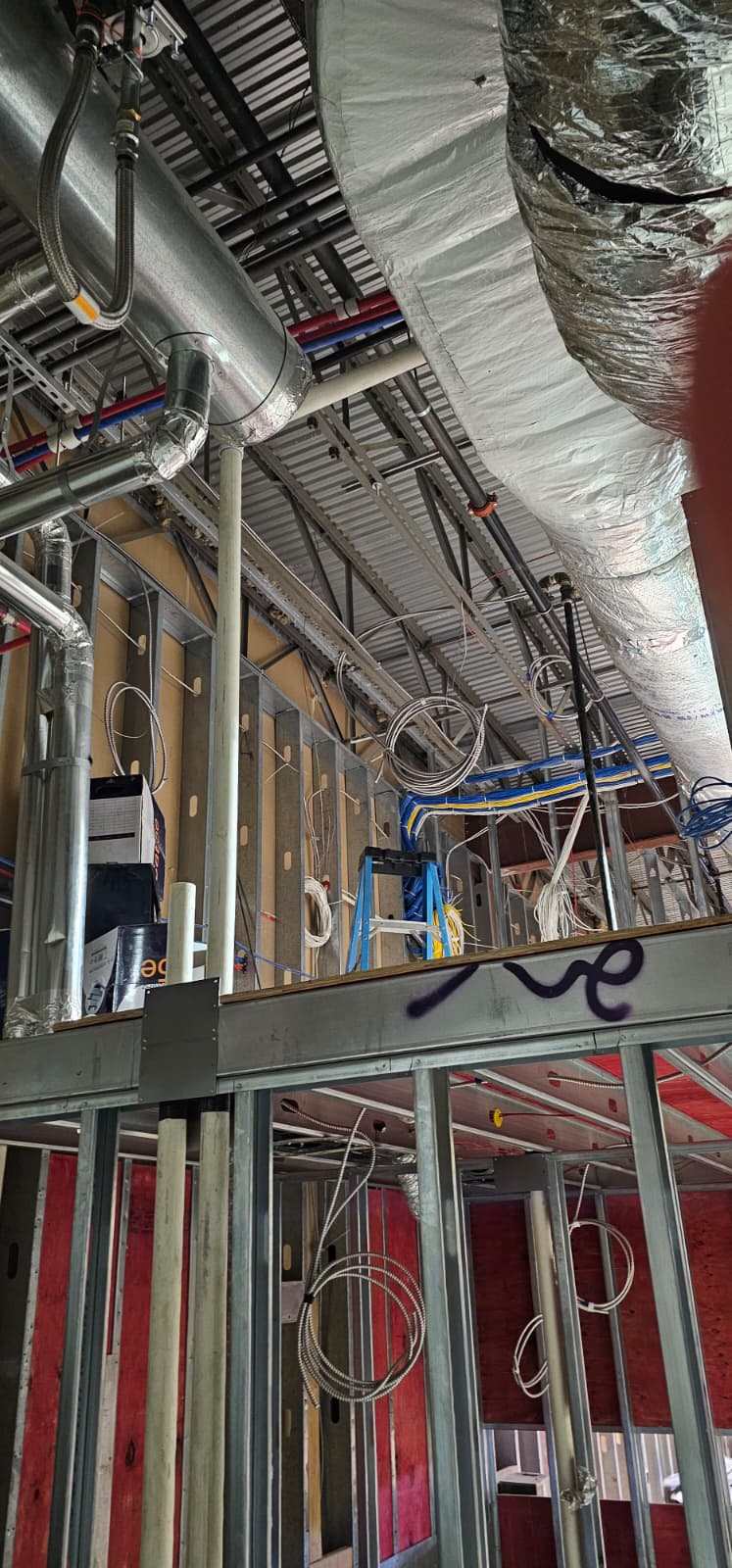 Low-voltage cable runs routed through open ceiling framing during construction