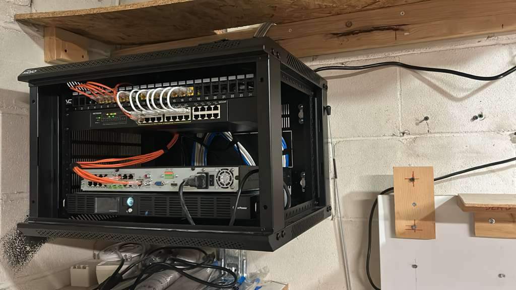 Organized open equipment rack with labeled switch, NVR, and UPS