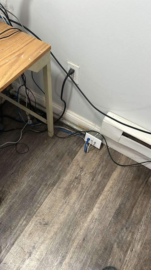 Network cabling neatly routed along the baseboard after cleanup