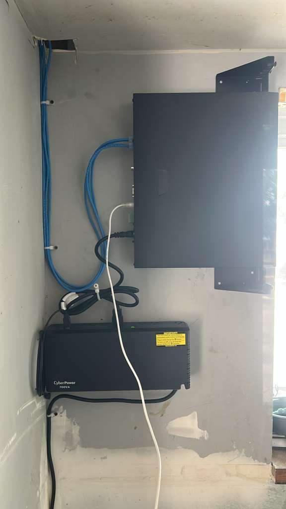 Wall-mounted NVR and UPS with organized blue cabling